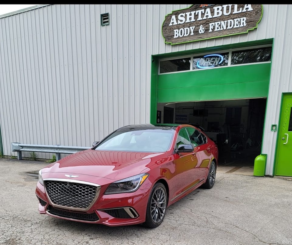 Freshly repaired red Genesis G80 parked outside Ashtabula Body & Fender