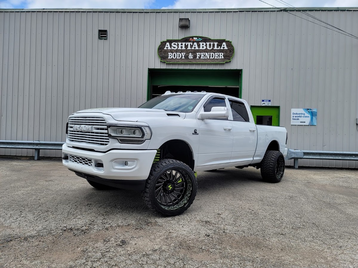 Lifted white Ram 2500 parked outside the shop after service