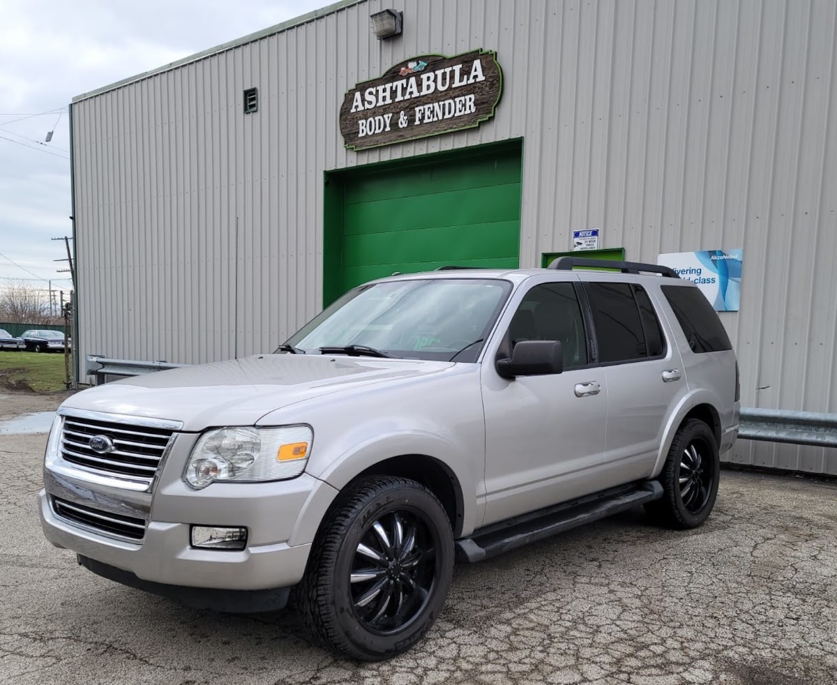 Silver Ford Explorer parked in front of the shop